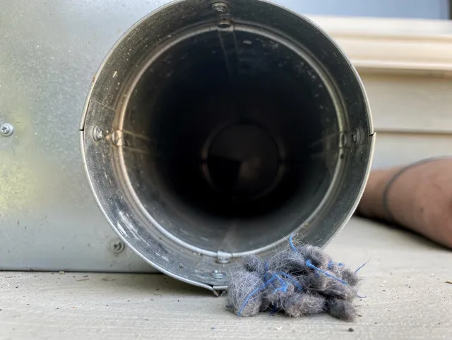 Burrillville Dryer Vent Cleaning technician using specialized equipment to clear severe dryer vent blockage in Burrillville